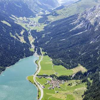 Luftaufnahme von Sufers mit Splügen im Hintergrund